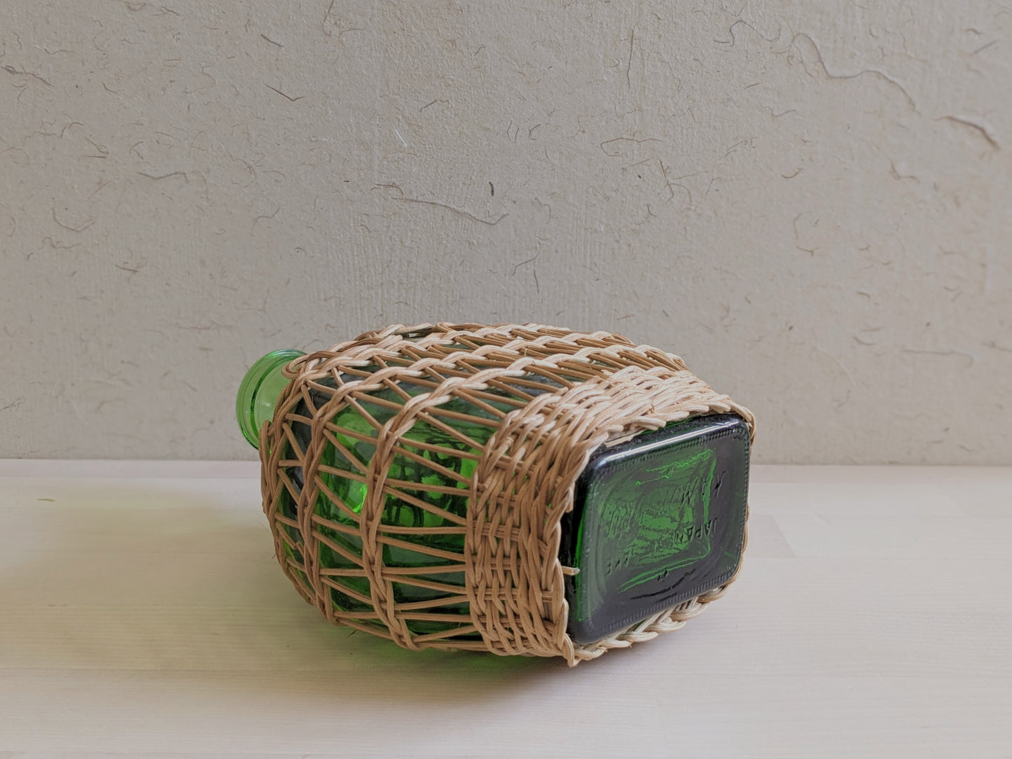 Vintage green glass sake bottle with weavings