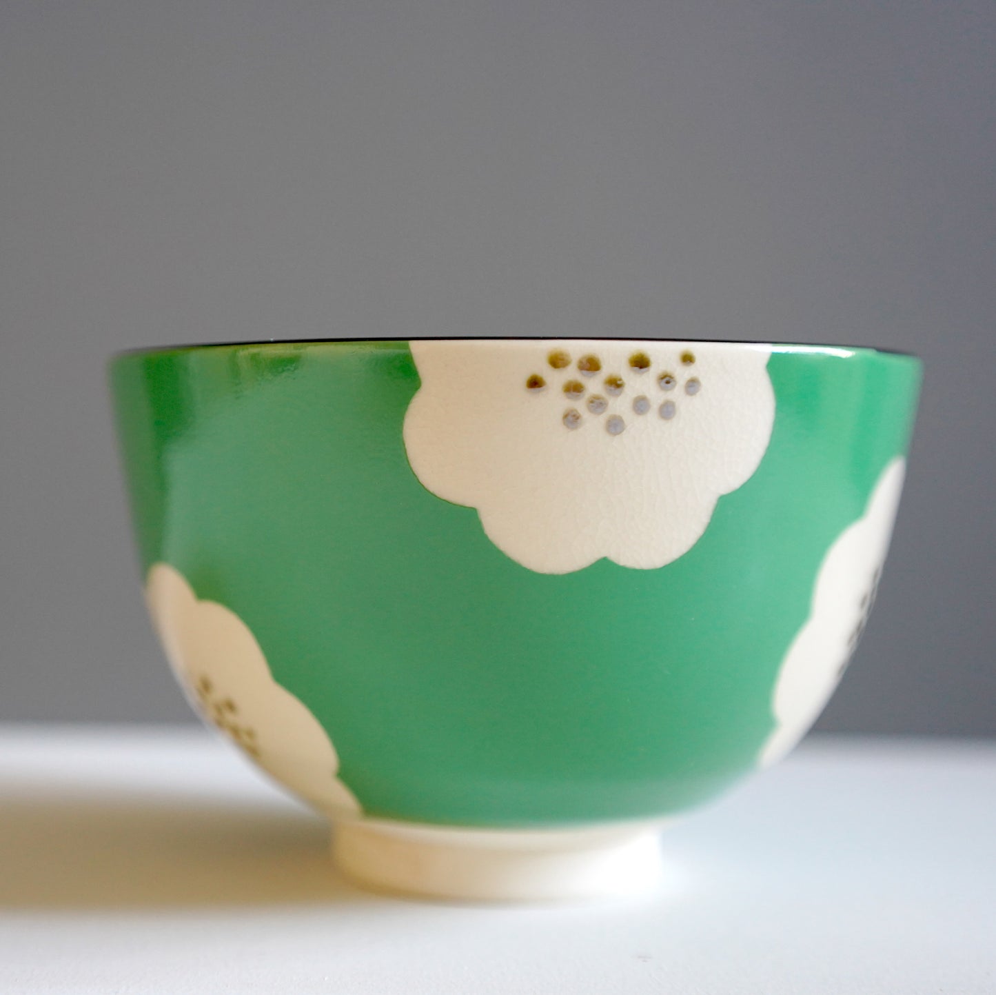 Green matcha bowl with white plum blossom