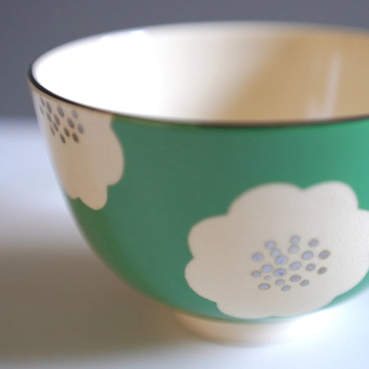 Green matcha bowl with white plum blossom